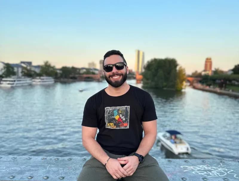 Smiling man sitting on a bridge