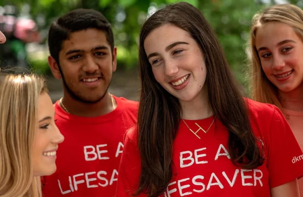 Young adults gathered with red Be a Lifesaver tshirts on for dkms