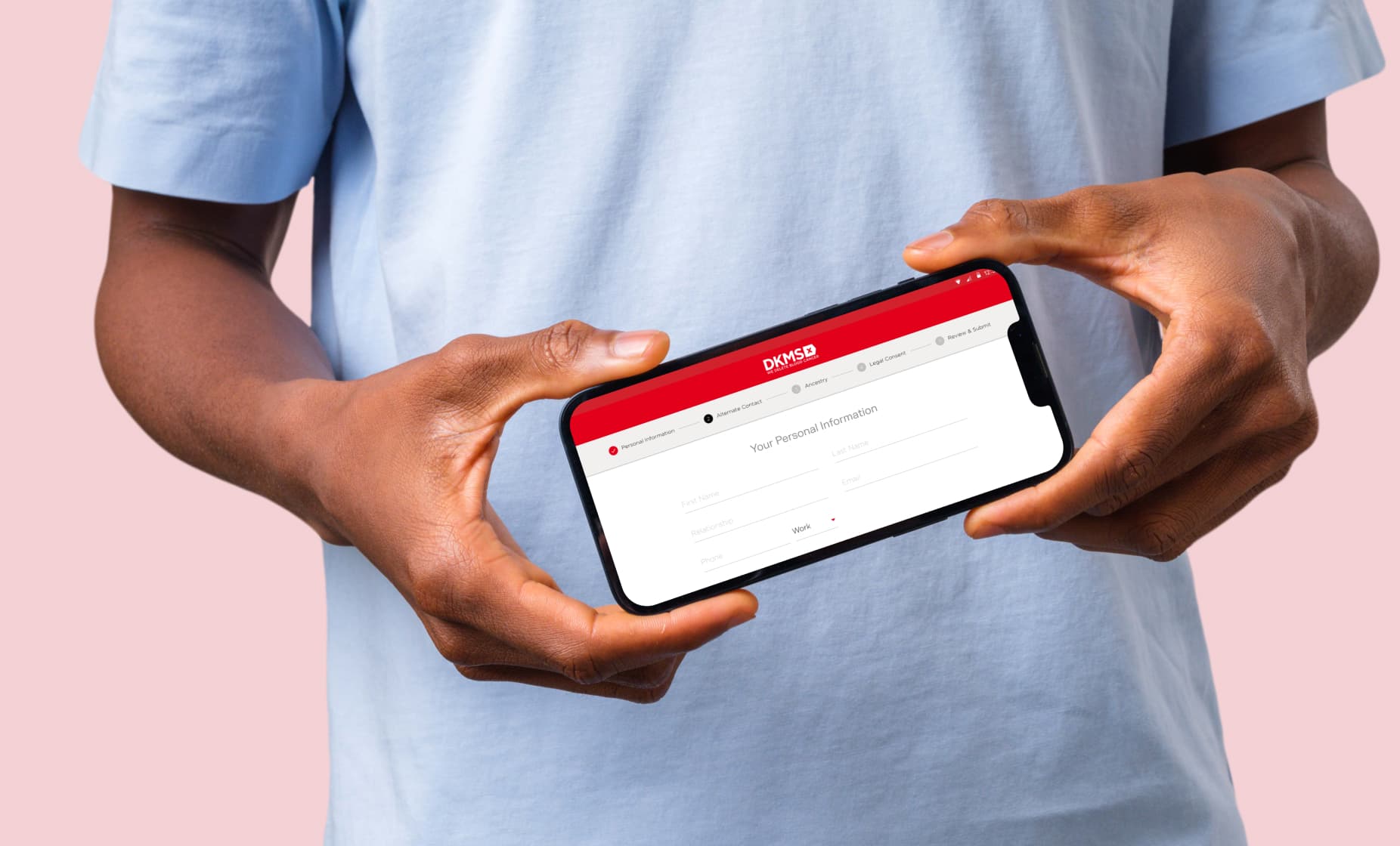 Male holding a mobile phone with the DKMS registration app