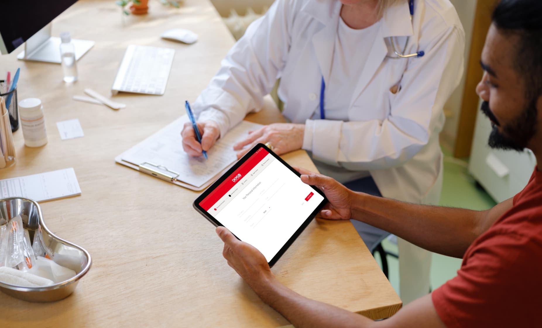 Nurse going over records with a patient who is registering on a tablet through the DKMS app