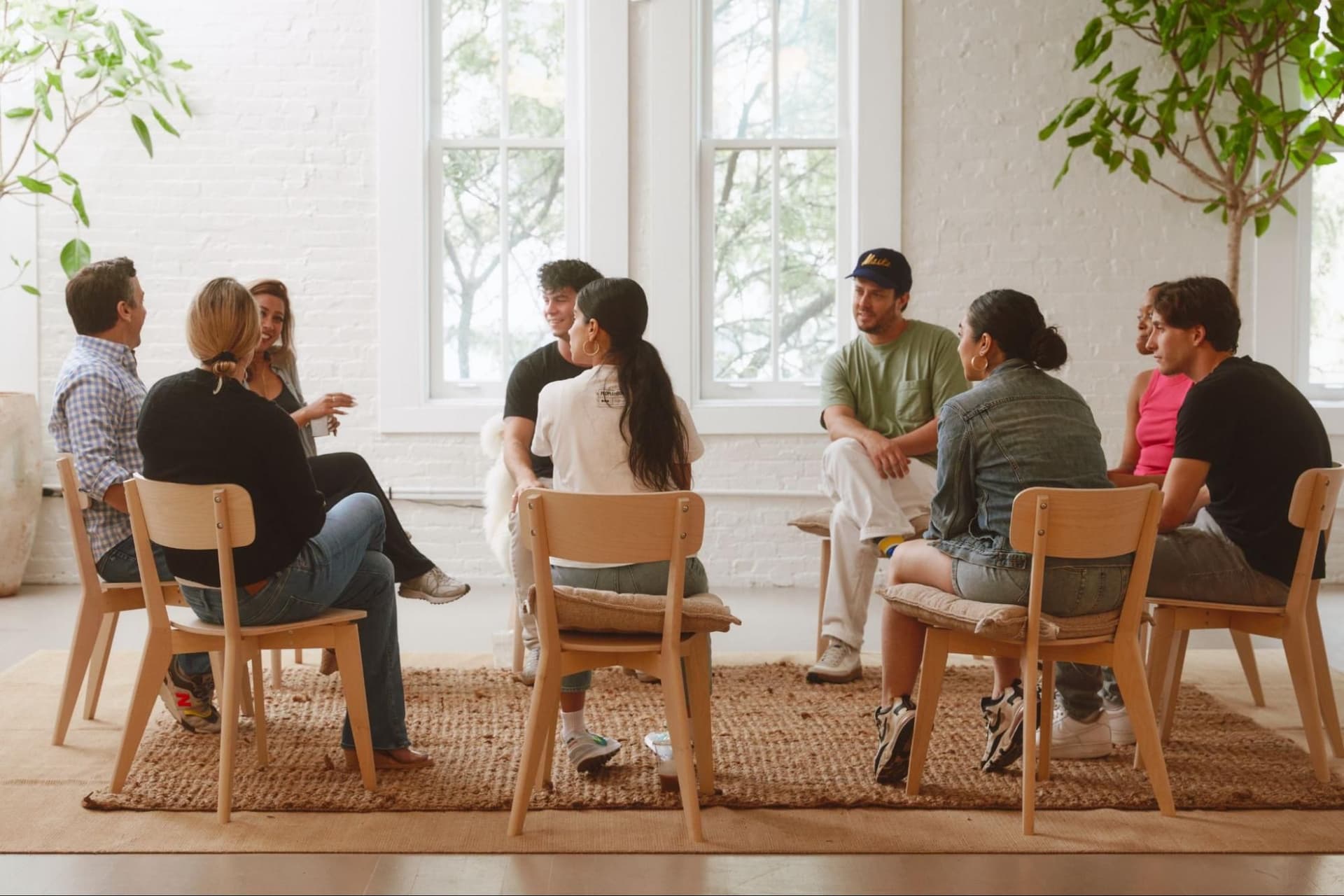 Group of men and women sitting in a circle talking